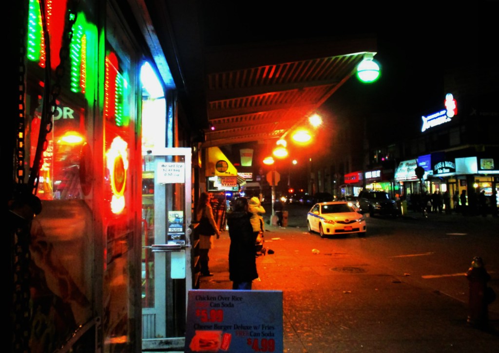 Featured image depicts a bus stop in an urban setting at night. The image features neon lights and moody lighting.